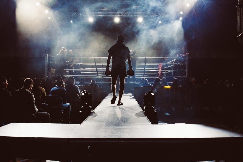 Man walking into a boxing ring.