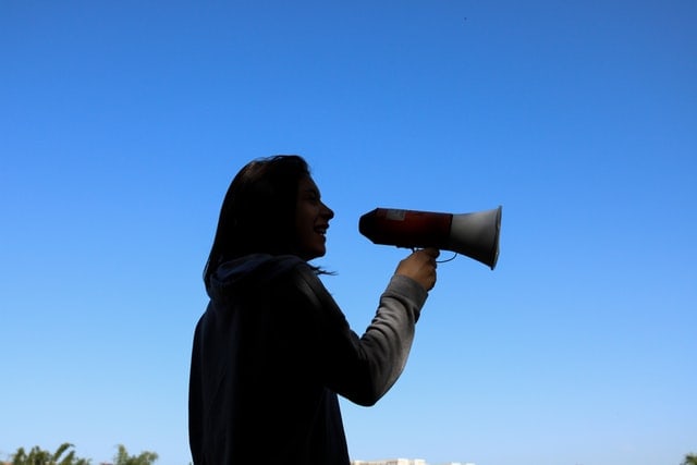 Woman speaking through a megaphone.