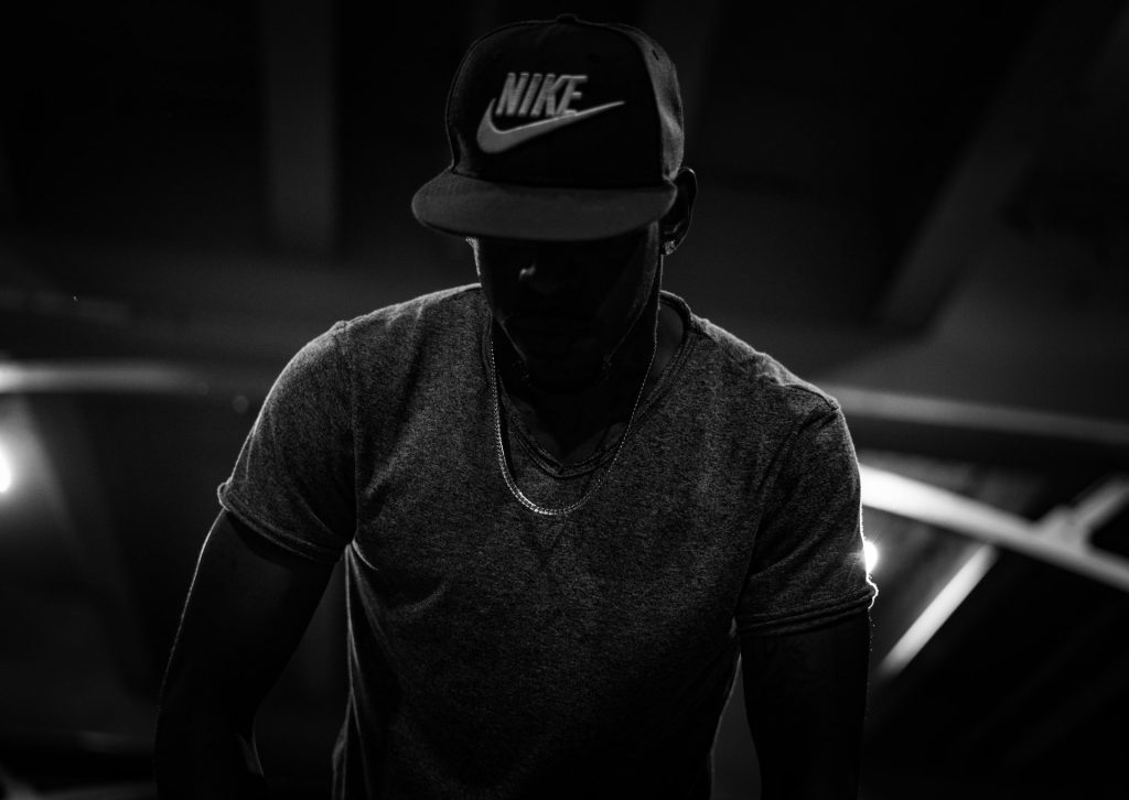 Black and white image of man wearing Nike cap.