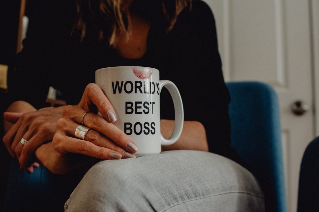 close up of woman holding mug that says world's best boss on it it