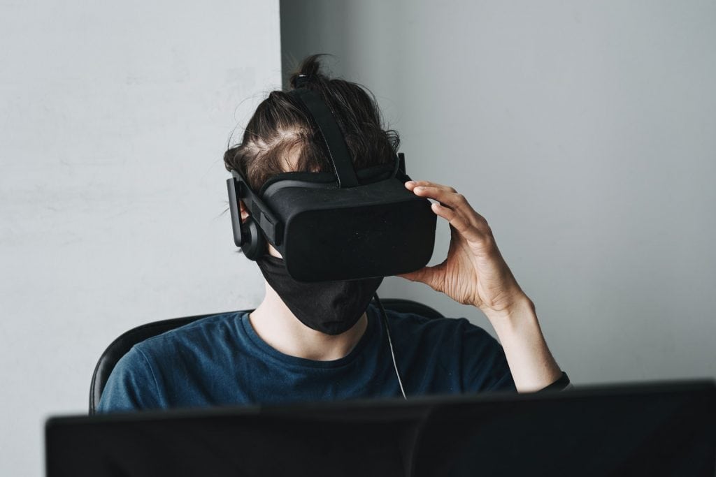man wearing virtual reality goggles at desk