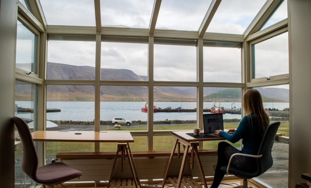 woman working in conservatory with beautiful view of lake and mountains