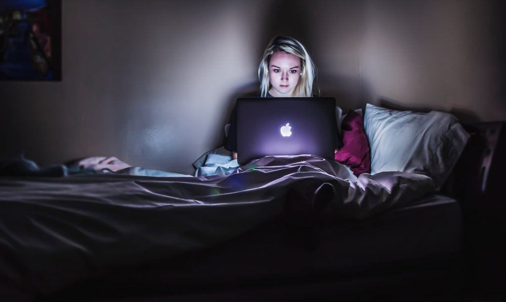 girl working on a laptop in the dark 