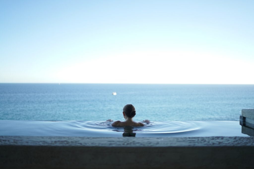 woman in infinity pool overlooking the ocean