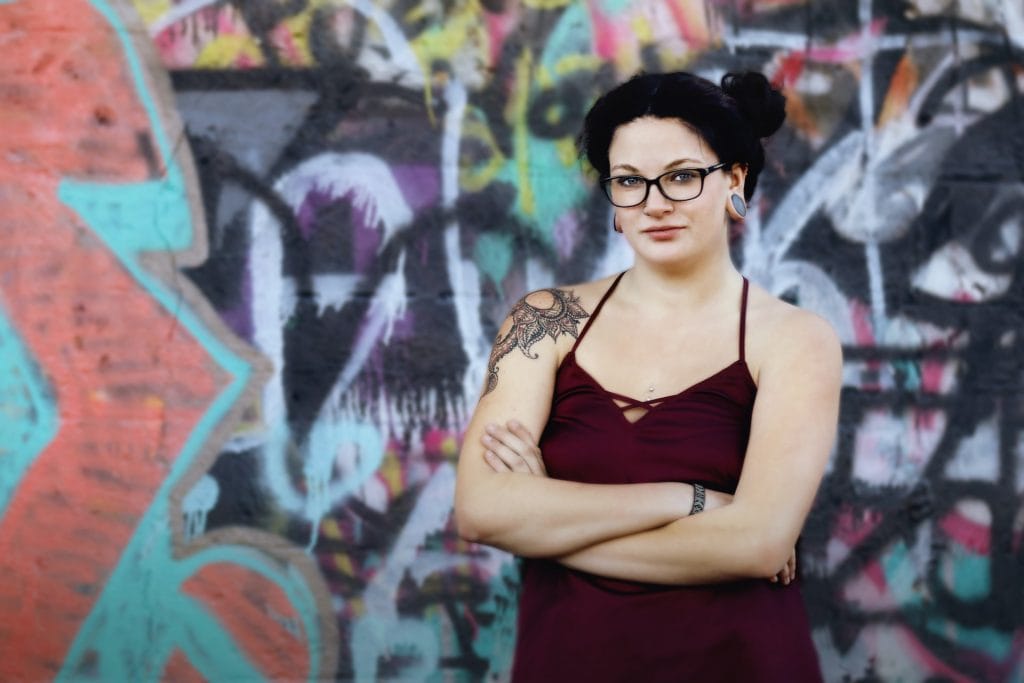 confident woman standing in front of graffiti wall